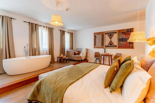 a bedroom with a large bed and a bath tub at Cangalho Village House Premium in Azueira