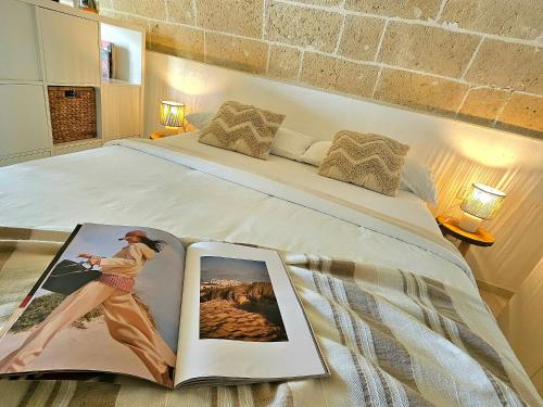 a bedroom with a bed with a book on it at Casa Lori,73 in Grottaglie