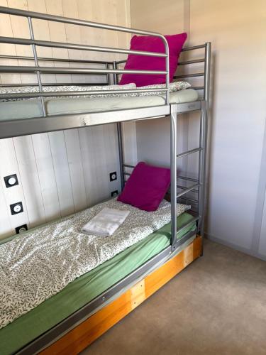 two bunk beds in a room with purple pillows at Cottage 79 Landes nature in Saubrigues