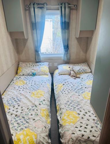 two beds in a small room with a window at Riverside 24 - Haggerston Castle in Berwick-Upon-Tweed