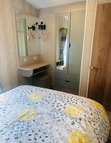 a bedroom with a bed and a sink and a mirror at Riverside 24 - Haggerston Castle in Berwick-Upon-Tweed
