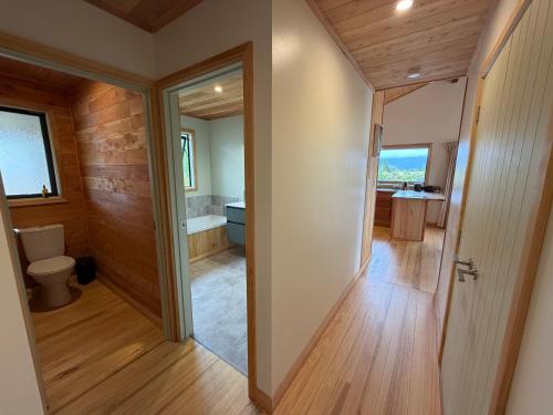 a bathroom with a toilet and a bath tub at Whare Aorere in Collingwood