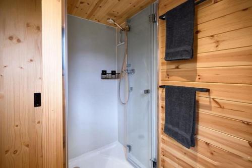 ein Badezimmer mit Dusche und weißer Badewanne in der Unterkunft Tiny BlackandWood in Redu
