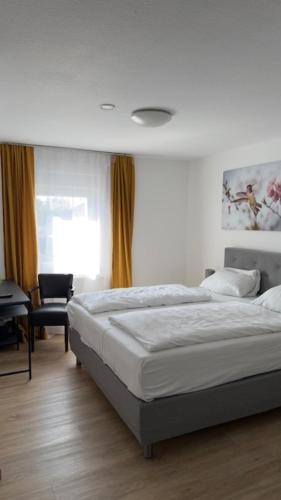 a bedroom with a bed and a desk and a chair at Hotel Alden in Aldenhoven