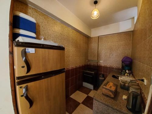 a small kitchen with a refrigerator and a sink at Heidi's House in Dahab