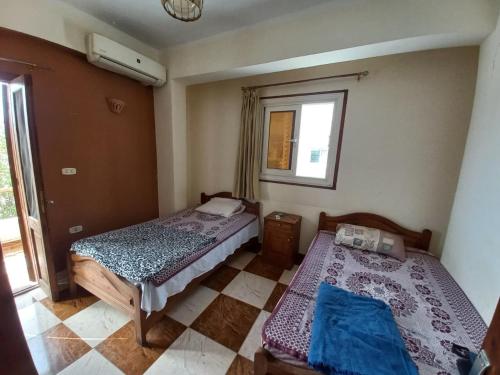 two beds in a room with a window at Heidi's House in Dahab