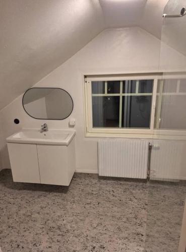a bathroom with a sink and a mirror and a window at Nordic DeLight in Skelleftehamn