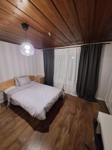a bedroom with a white bed and a wooden ceiling at Nordic DeLight in Skelleftehamn