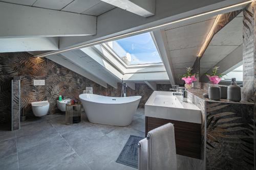 a large bathroom with a tub and a sink at Attico Mansardato con terrazzo privato in Monza