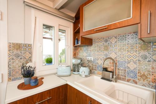 a kitchen with a sink and a window at Aegean Balcony Apartment in Nea Peramos