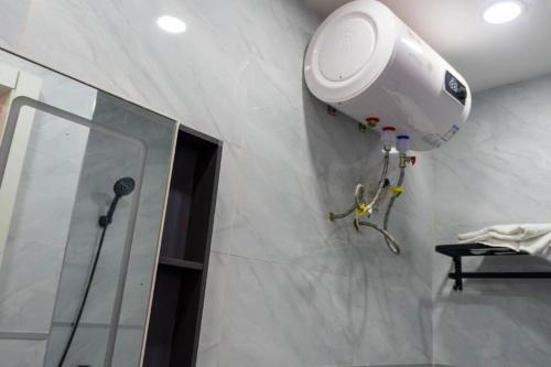 a bathroom with a shower and a camera on the wall at Résidence Madior C3 in Dakar