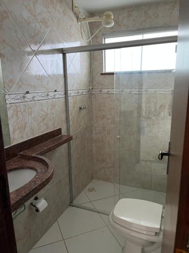 ein Badezimmer mit Dusche, Toilette und Waschbecken in der Unterkunft Flat Granito e Jasmim in Conde