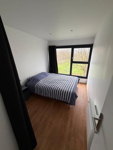 a small bedroom with a bed and a window at Saint Pierre Gîte in Ambleteuse