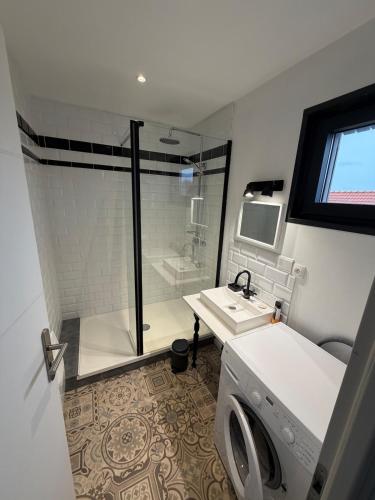 a bathroom with a shower and a washing machine at Saint Pierre Gîte in Ambleteuse