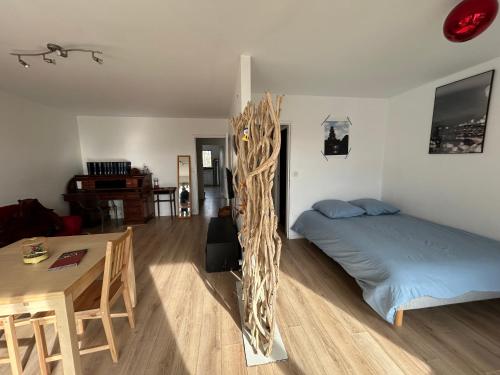 a bedroom with a bed and a table in it at appartement vincennes avec balcon in Vincennes