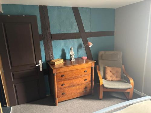 a bedroom with a dresser and a chair and a lamp at Appart familial in Kogenheim