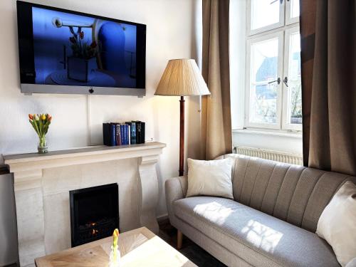a living room with a couch and a fireplace at eXo Hotel Franka Bamberg - by NeVo Hotels in Hallstadt