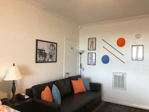 a living room with a black couch and orange and blue pillows at King Bed Condo at Cedar Breaks Lodge in Brian Head