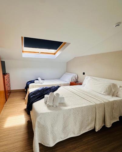 a bedroom with two beds and a skylight at Hotel Maria del Mar in Noja