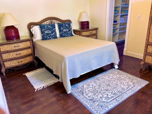 a bedroom with a bed with blue pillows and a rug at The Blue Inn Family Vacation Rental in Smith Point