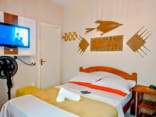 a bedroom with a bed and a flat screen tv at Rancho Magic in Cabo Frio