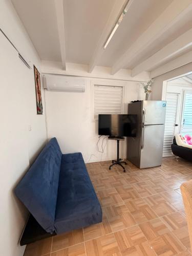 a living room with a blue couch and a refrigerator at Villa Lumineuse in Le Lamentin