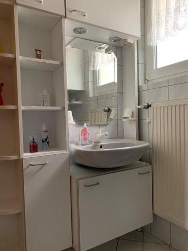 a white bathroom with a sink and a mirror at Seppel's Häuschen in Bad Orb