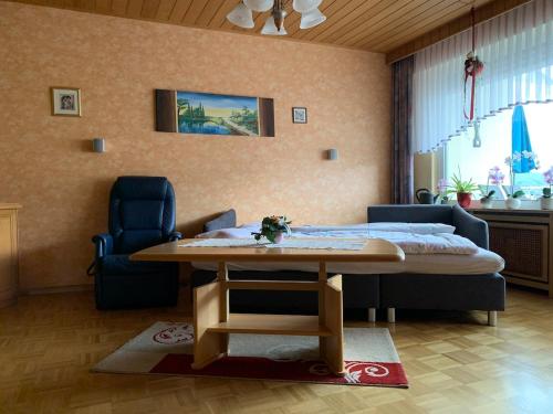 a living room with a table and a bed at Seppel's Häuschen in Bad Orb