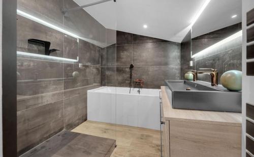 a bathroom with a tub and a sink at CALME - 15 min Toulouse - PISCINE - SPA in Mons