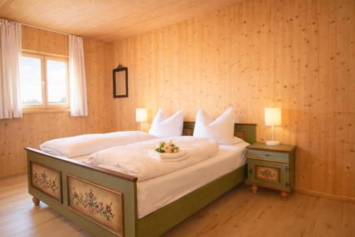 a bedroom with a bed with a bowl of fruit on it at ChiemseeRefugium - Ferienwohnung Berg in Bernau am Chiemsee