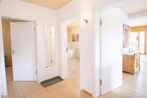 a room with white walls and a white door at ChiemseeRefugium - Ferienwohnung Berg in Bernau am Chiemsee