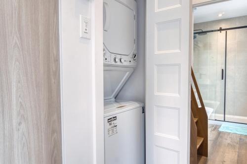 a bathroom with a washer and dryer next to a door at Maison Eadda in Adstock