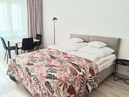 a bedroom with a bed and a table and chairs at Apartament Bursztynowy in Ustka