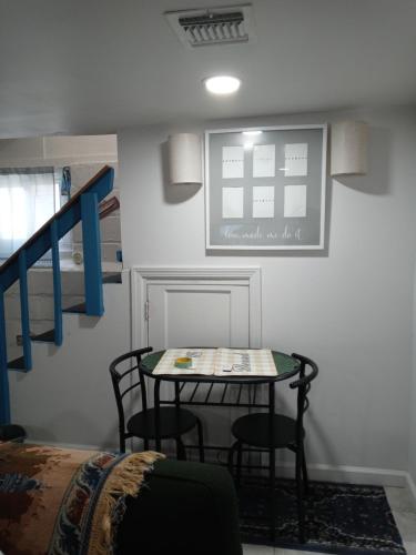 a table and chairs in a room with a staircase at "Cozy Basement Retreat Just 40 Minutes to NYC!" in Irvington