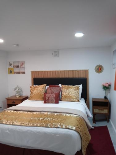 a bedroom with a large bed with gold pillows at "Cozy Basement Retreat Just 40 Minutes to NYC!" in Irvington
