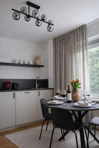 a dining room with a table and chairs and a kitchen at Bergen Delight in Bergen