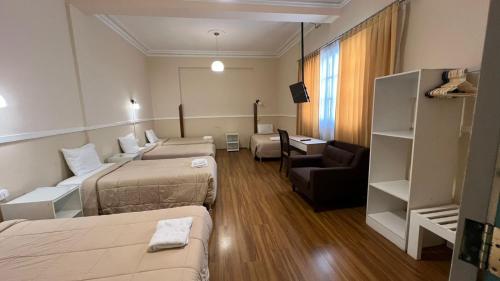 a hotel room with two beds and a couch at Los Andes Bed & Breakfast in Arequipa