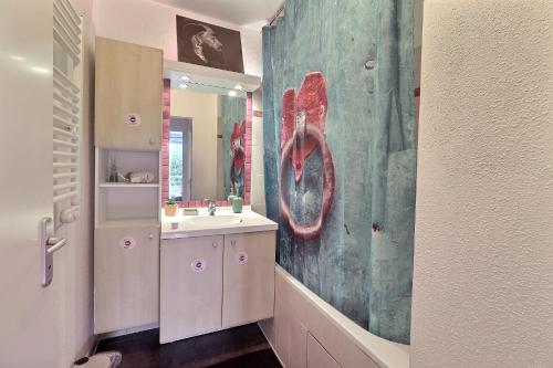a bathroom with a sink and a large painting on the wall at Urban Escape - Piscine & Terrasse intime à 3 min du Parc des Coquibus - Proche ORLY in Courcouronnes