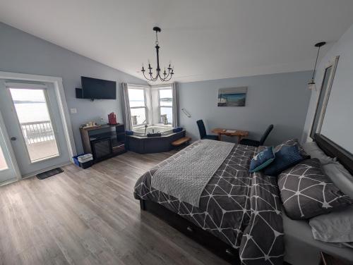 a bedroom with a bed and a bathroom with windows at Dildo Boathouse Inn in Dildo