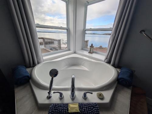 a bath tub in a room with a window at Dildo Boathouse Inn in Dildo