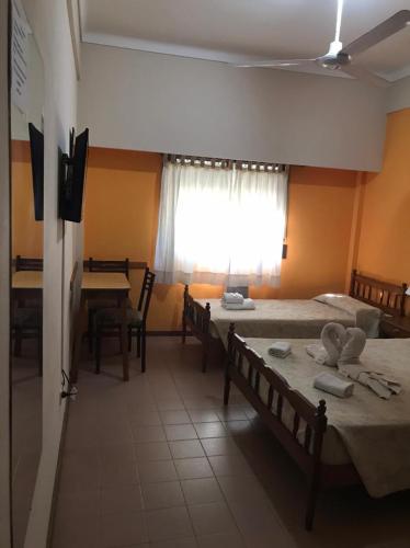 a hotel room with two beds and a window at Hotel JR in Mar del Tuyú