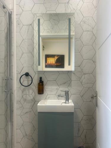 a white bathroom with a sink and a mirror at Sauna flat Central Brighton in Brighton & Hove