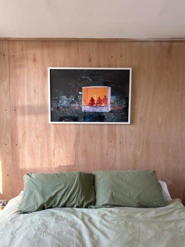 a bed with a wooden headboard with a picture above it at Sauna flat Central Brighton in Brighton & Hove