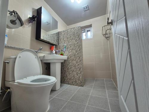 a bathroom with a toilet and a sink and a shower at 비우리게스트하우스 in Kujŏm