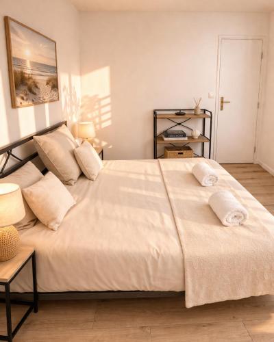 a bedroom with a large bed with two pillows at L Echappee Jardin prive proche plage Sainte Cecile in Camiers