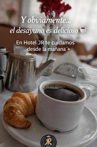 a cup of coffee and a croissant on a table at Hotel JR in Mar del Tuyú