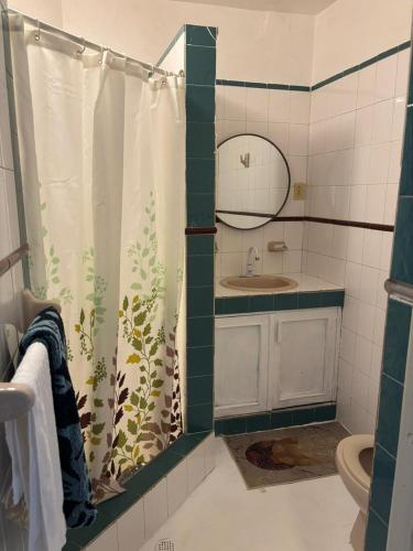 a bathroom with a shower curtain with a sink at Hotel Restaurant Wuarao - Antiguo Club Rolling Stones in Boca Chica