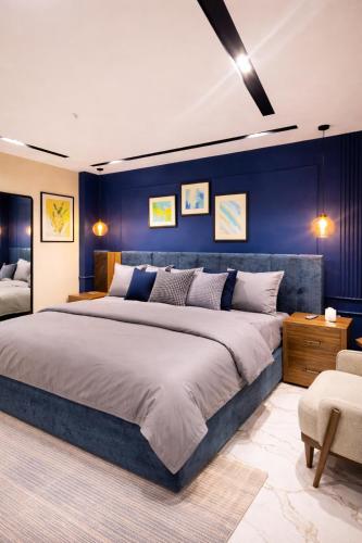 ein Schlafzimmer mit einem großen Bett und einer blauen Wand in der Unterkunft LMY Murree Boutique Apartments - Expressway Near Coffee Bean in Lower Topa