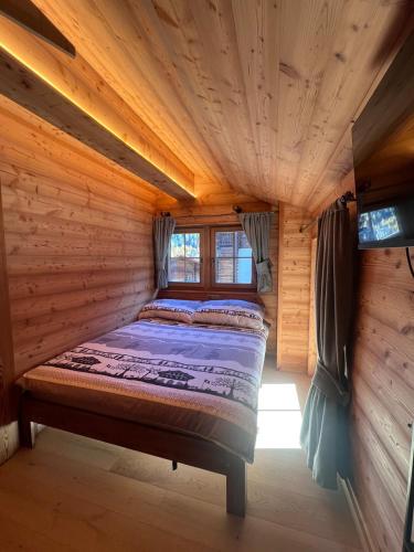 a bedroom in a log cabin with a bed in it at La Grangette in Grimentz