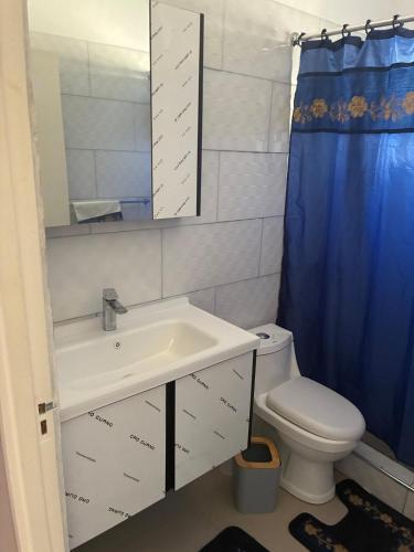 a bathroom with a sink and a toilet and a mirror at Grace in Spanish Town